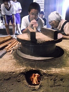 火吹き竹を使ってカマドの火を強めます