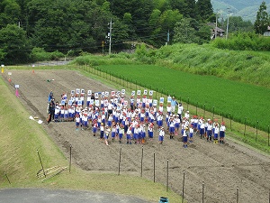 地域の方と一緒に種まき終了後に記念写真